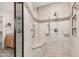 Detailed view of a tiled walk-in shower with a built-in seat and convenient grab bar at 8303 E Monterey Ave, Mesa, AZ 85209