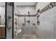 Modern bathroom shower with neutral tile, built-in shelving, a shower bench, and a convenient grab bar at 8303 E Monterey Ave, Mesa, AZ 85209