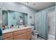 Powder blue bathroom featuring a single sink vanity, large mirror and a shower with tile surround at 8303 E Monterey Ave, Mesa, AZ 85209