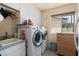 Bright laundry room featuring a washer and dryer, a utility sink, storage cabinets and natural light at 8303 E Monterey Ave, Mesa, AZ 85209