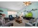 Spacious living room features teal walls, neutral carpet, a brown sofa, and a flat-screen TV for entertainment at 8303 E Monterey Ave, Mesa, AZ 85209