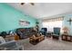 Comfortable living room featuring teal walls, neutral carpet, a brown sofa, and an array of inviting seating options at 8303 E Monterey Ave, Mesa, AZ 85209