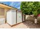 Backyard storage shed with easy access and a low-maintenance gravel yard with mature trees at 8303 E Monterey Ave, Mesa, AZ 85209