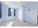 Bright bedroom with soft blue walls, one window with blue curtains, neutral carpet, and ceiling fan at 8720 N 182Nd Ln, Waddell, AZ 85355