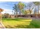 Spacious backyard showcasing a well-manicured lawn, mature trees, and a decorative fountain at 1043 W Washington Ave, Gilbert, AZ 85233