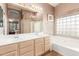 Bright bathroom features a double sink vanity, soaking tub, and a separate glass enclosed shower at 1043 W Washington Ave, Gilbert, AZ 85233