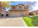 Two-story home with a two-car garage, green grass, and desert landscaping at 1043 W Washington Ave, Gilbert, AZ 85233