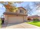 Beige two-story home with two-car garage, green grass, and desert landscaping at 1043 W Washington Ave, Gilbert, AZ 85233