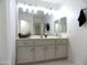 Bright bathroom featuring a spacious vanity with white cabinets, a large mirror, and decorative accents at 10549 E Cedar Waxwing Dr, Sun Lakes, AZ 85248