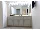 Bright bathroom featuring a spacious vanity with white cabinets, a large mirror, and decorative accents at 10549 E Cedar Waxwing Dr, Sun Lakes, AZ 85248