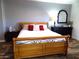 Cozy main bedroom featuring wood flooring, a comfortable bed, dresser, and decorative mirror at 10549 E Cedar Waxwing Dr, Sun Lakes, AZ 85248