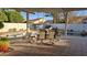 Covered patio with outdoor dining set next to sparkling pool and lush landscape, perfect for entertaining at 10549 E Cedar Waxwing Dr, Sun Lakes, AZ 85248