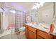 Bathroom featuring tile floors, wood vanity, and shower-tub combo with curtain at 10846 N Fairway E Ct, Sun City, AZ 85351