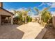 Expansive backyard features a large patio, desert landscaping, mature palm trees, and a custom fire pit at 11128 E Segura Ave, Mesa, AZ 85212