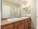 Bathroom featuring double sinks with framed mirrors and wooden cabinets at 11128 E Segura Ave, Mesa, AZ 85212