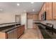 Modern kitchen featuring stainless steel appliances, granite counters, wood cabinetry and tile floor at 11128 E Segura Ave, Mesa, AZ 85212