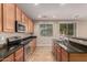 Spacious kitchen features black granite countertops, stainless steel appliances, and tile floors at 11128 E Segura Ave, Mesa, AZ 85212