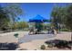 Brightly colored playground featuring climbing structures and slides with a sun shade and landscaping at 11128 E Segura Ave, Mesa, AZ 85212