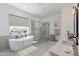 Bright bathroom featuring soaking tub, glass shower, double vanity, and modern neutral decor at 11230 E Crescent Ave, Mesa, AZ 85208