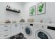 Laundry room features cabinetry, counterspace, shelving, modern washer and dryer, and decor at 11230 E Crescent Ave, Mesa, AZ 85208