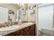 Bright bathroom with a granite countertop, dual sinks, warm-toned cabinets, and a decorative theme at 12610 E Cortez Dr, Scottsdale, AZ 85259