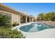 Backyard view with a pool, patio, and landscaped yard surrounded by plants and palm trees at 12610 E Cortez Dr, Scottsdale, AZ 85259