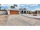 Inviting single-story home featuring a unique desert landscape, brown garage, and arched entryway at 13845 N 41St Ave, Phoenix, AZ 85053