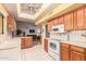 Well-lit kitchen with white tile flooring, light wood cabinets, and an efficient layout for cooking and meal prep at 14718 W Ravenswood Dr, Sun City West, AZ 85375