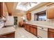 Practical kitchen design featuring white appliances, light wood cabinets, and a view to the adjacent dining area at 14718 W Ravenswood Dr, Sun City West, AZ 85375