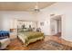 Bright bedroom featuring a ceiling fan, hardwood floors, built-in cabinets, and access to the ensuite bath and outdoor living area at 14718 W Ravenswood Dr, Sun City West, AZ 85375