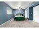 Bedroom with blue walls, ceiling fan, windows, and carpet flooring at 1578 W Campbell Ave, Phoenix, AZ 85015