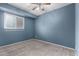 Carpeted bedroom with large window, a ceiling fan, and blue painted walls at 1578 W Campbell Ave, Phoenix, AZ 85015