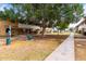 Community scene featuring a giant shade tree, sidewalks, trash receptacle, and several townhomes at 1578 W Campbell Ave, Phoenix, AZ 85015