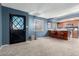 Spacious living area featuring a custom glass door, bar seating, and carpet flooring at 1578 W Campbell Ave, Phoenix, AZ 85015