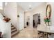 Inviting entryway with travertine floors, stairway, and view to a powder room and living room at 16600 N Thompson Peak Pkwy # 1052, Scottsdale, AZ 85260