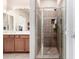 A primary bathroom with a tiled glass-enclosed shower, wood cabinets, and double sinks at 16600 N Thompson Peak Pkwy # 1052, Scottsdale, AZ 85260