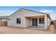 Back exterior of home showcasing backyard with concrete patio and desert landscaping at 16778 W Yucatan Dr, Surprise, AZ 85378