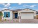 Charming single-story home showcasing a tidy front yard, blue door, and a two-car garage at 16778 W Yucatan Dr, Surprise, AZ 85378
