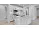 Bright, modern kitchen features white cabinetry, stainless steel appliances, and a sleek island at 16778 W Yucatan Dr, Surprise, AZ 85378