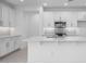 Bright, modern kitchen features white cabinetry, stainless steel appliances, and a sleek island at 16778 W Yucatan Dr, Surprise, AZ 85378