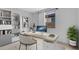 A bright and modern home office with a large desk, shelving unit and a view to the outside at 16778 W Yucatan Dr, Surprise, AZ 85378