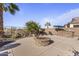 Landscaped backyard with a stone firepit, citrus trees, and lounge seating at 17634 W Verdin Rd, Goodyear, AZ 85338