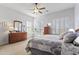 Bright bedroom with carpet, ceiling fan, and shuttered windows at 17634 W Verdin Rd, Goodyear, AZ 85338