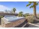 Inviting backyard hot tub featuring stone surround and lush desert landscaping at 17634 W Verdin Rd, Goodyear, AZ 85338