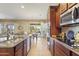 Modern kitchen featuring stainless steel appliances, custom cabinetry, and a breakfast bar overlooking the dining area at 17634 W Verdin Rd, Goodyear, AZ 85338