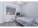 Neutral-toned bedroom featuring wood-look flooring, window, and a bed with decorative quilt at 18750 E Ryan Rd, Queen Creek, AZ 85142