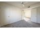 Bright bedroom featuring neutral walls, carpet, a ceiling fan, and an open doorway at 1905 E University Dr # 219, Tempe, AZ 85288