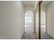 Hallway featuring arched doorways, carpeted floors, and a mirrored closet at 1905 E University Dr # 219, Tempe, AZ 85288