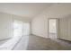 Bright, carpeted living room bathed in light, showcasing the serene interior and access to a private balcony at 1905 E University Dr # 219, Tempe, AZ 85288