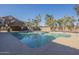 A wide view of the community pool surrounded by fencing and lush trees at 1905 E University Dr # 219, Tempe, AZ 85288